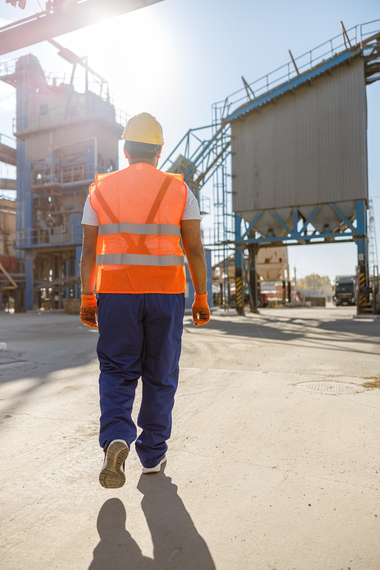 Young worker dressed in safety equipment inside factory